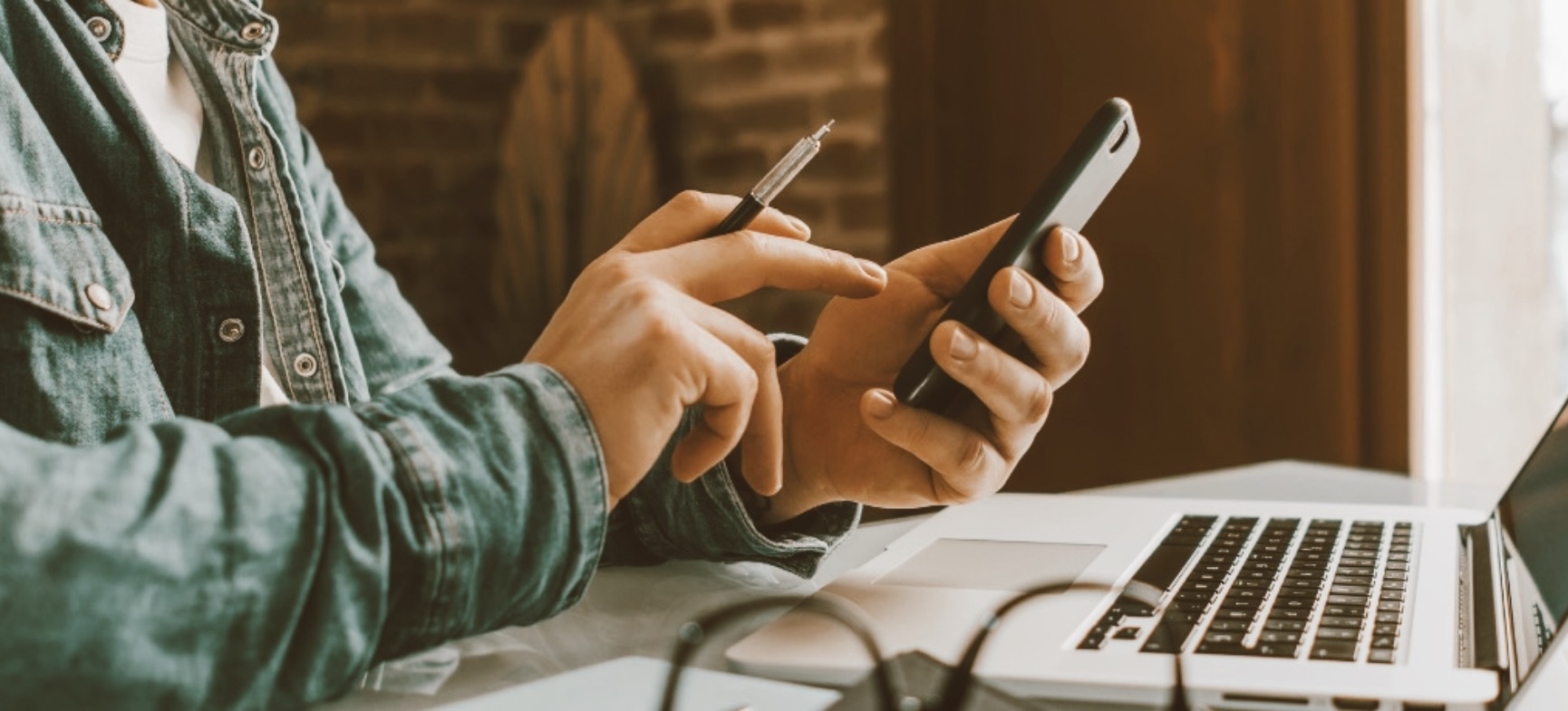 a person on their mobile phone and laptop computer